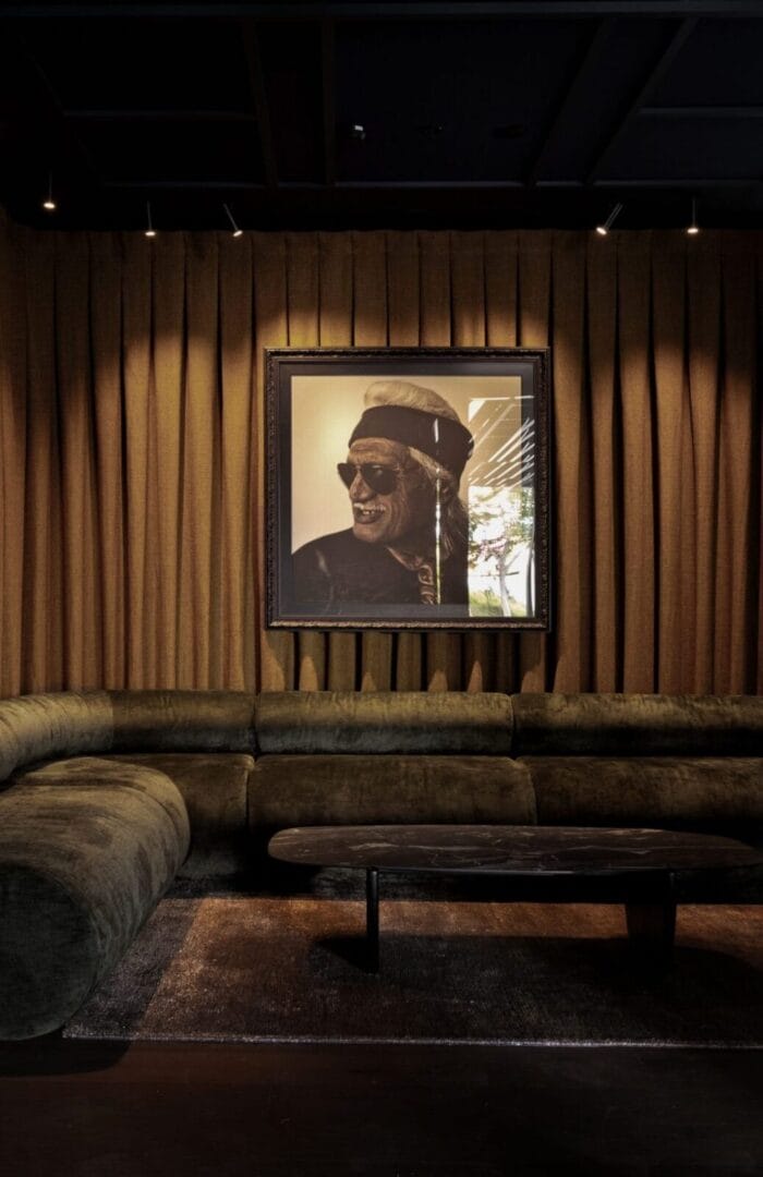 Velvet lounge with portrait art at Abstract Hotel, featuring rich textures and moody lighting.