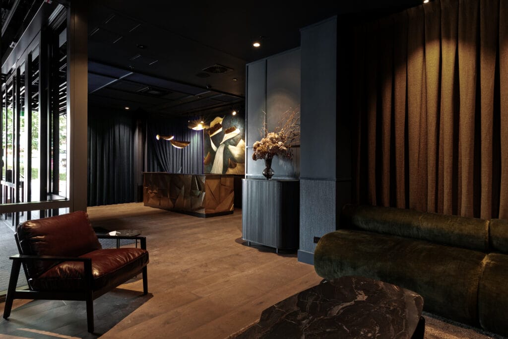 Moody and modern hotel lobby with artistic lighting, dark interiors, and designer furniture.
